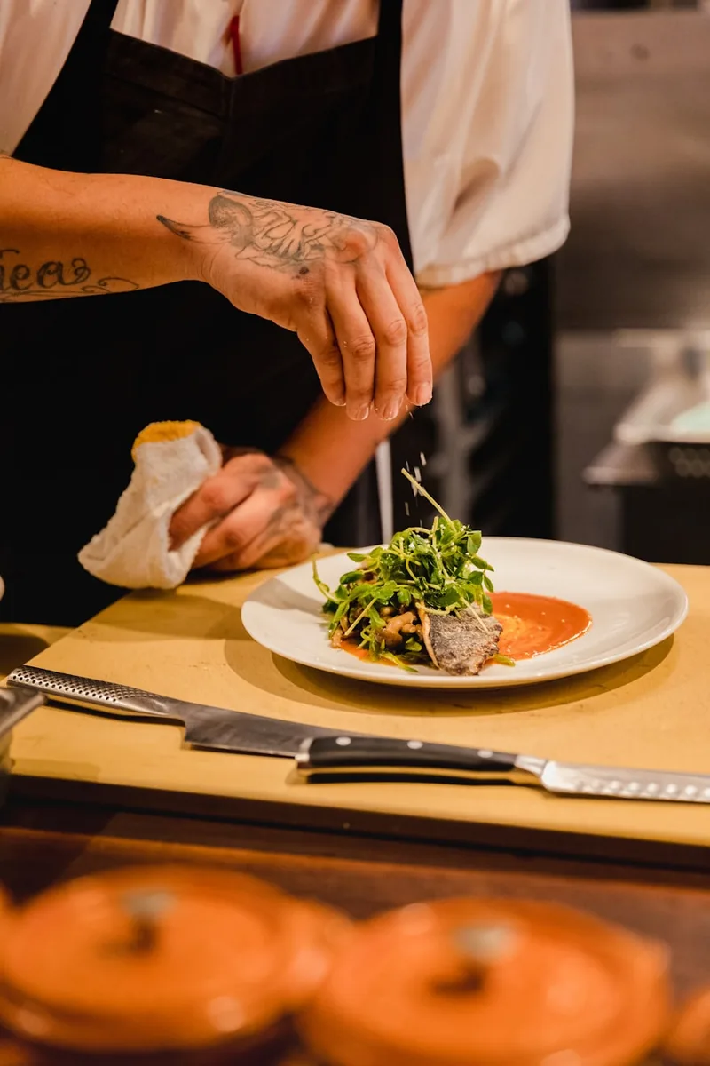 Chef à domicile dressant une assiette gastronomique