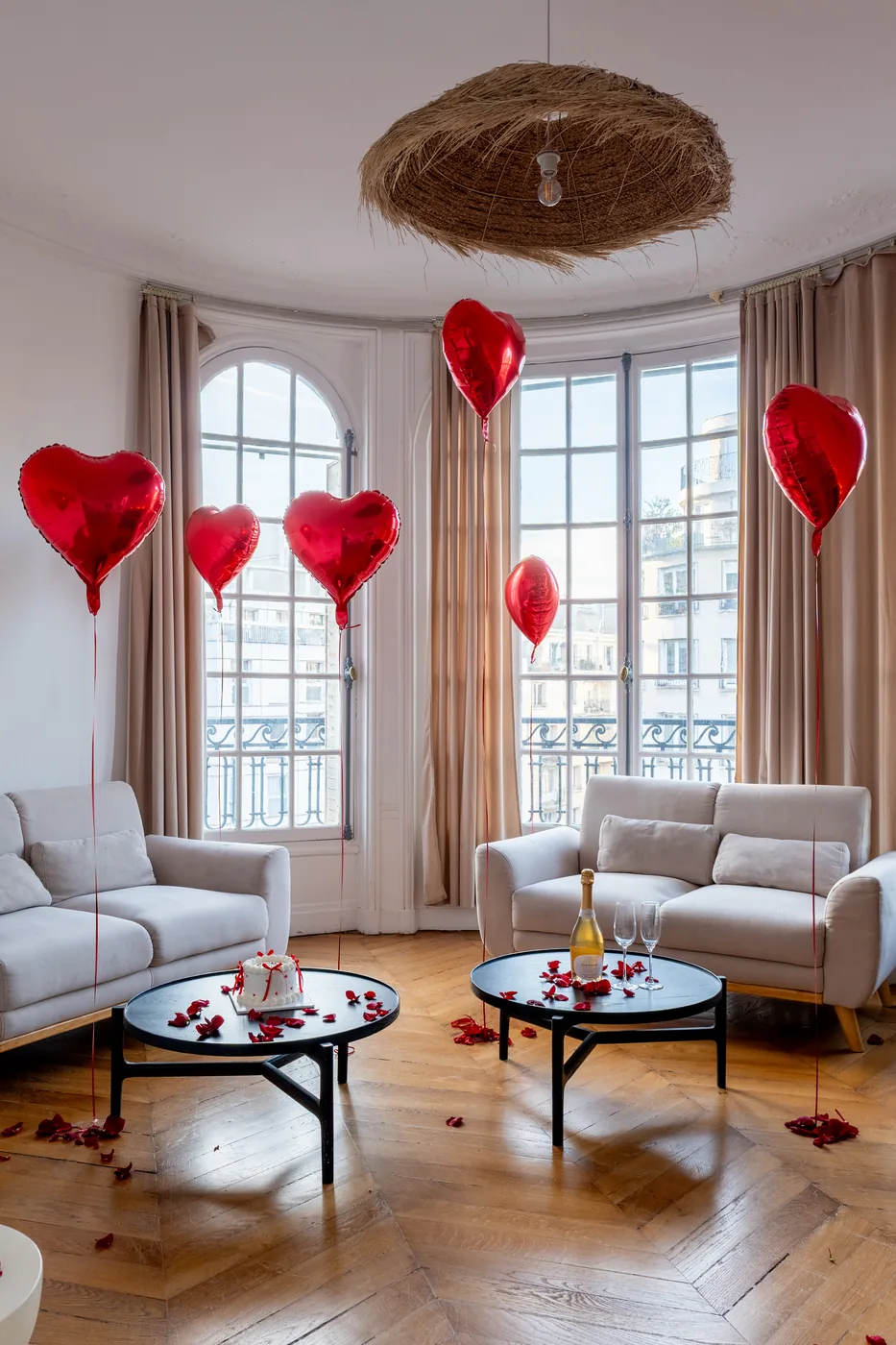 Coffret Love Expérience : salon parisien décoré de ballons cœur, champagne et pétales de roses